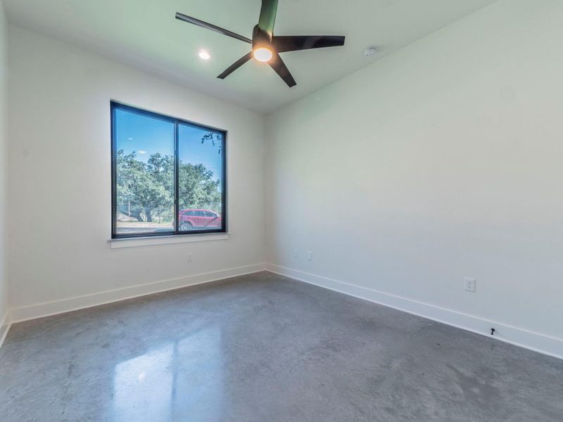 Empty room featuring finished concrete floors, ceiling fan, and recessed lighting Empty room featuring finished concrete floors, ceiling fan, and recessed lighting
