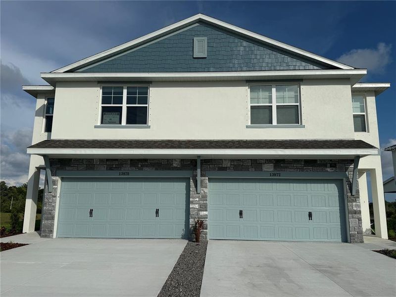Front exterior of a new home in Emerald Fields, Hudson, FL, highlighting curb appeal (Image 1). Front exterior of a new home in Emerald Fields, Hudson, FL, highlighting curb appeal (Image 1).