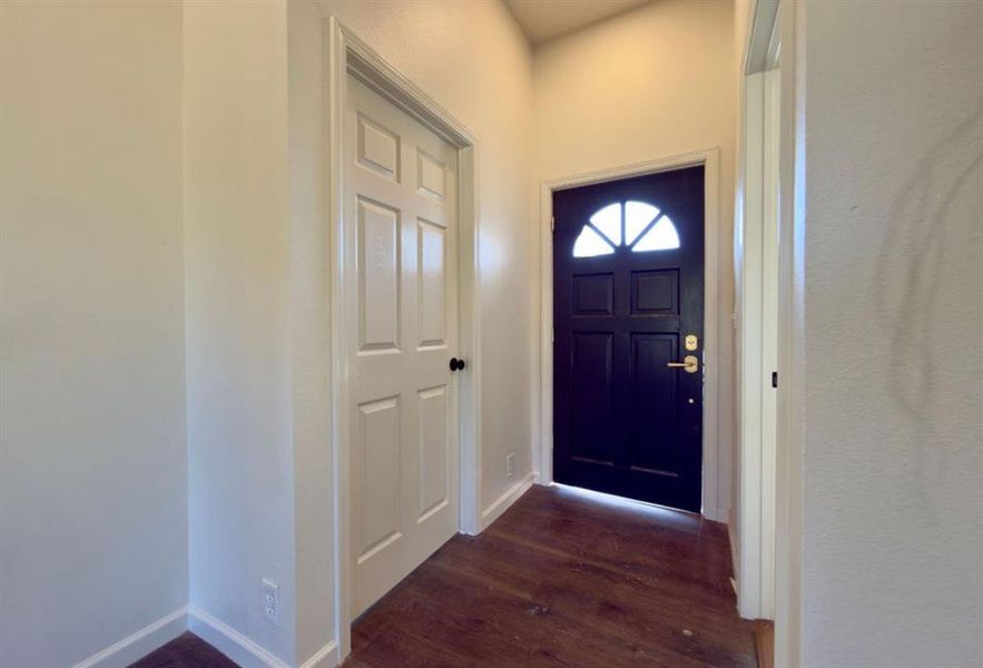 Entrance foyer featuring dark wood-type flooring and baseboards Entrance foyer featuring dark wood-type flooring and baseboards