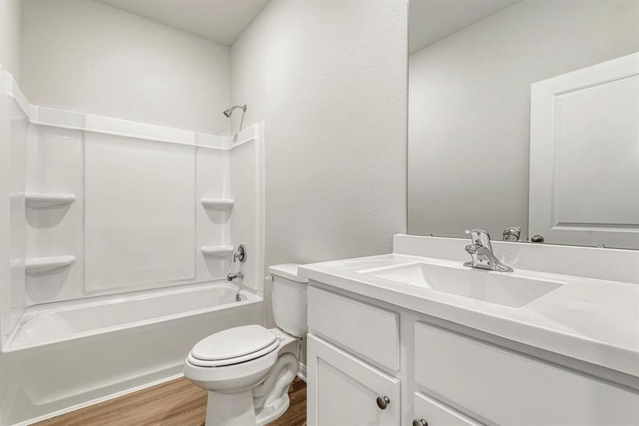 The centrally located secondary bathroom has an upgraded shower/bath combo and single basin sink with beautiful cabinetry.