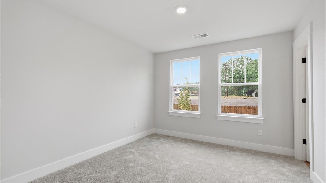 Highly functional bedroom with large windows, carpeted flooring, and tasteful finishes throughout at Woodglen Highly functional bedroom with large windows, carpeted flooring, and tasteful finishes throughout at Woodglen