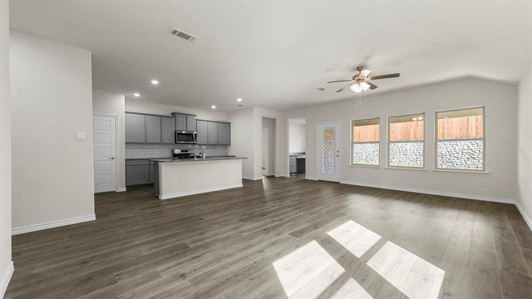 Open-concept living area featuring wood-finish flooring, recessed lighting, and a ceiling fan