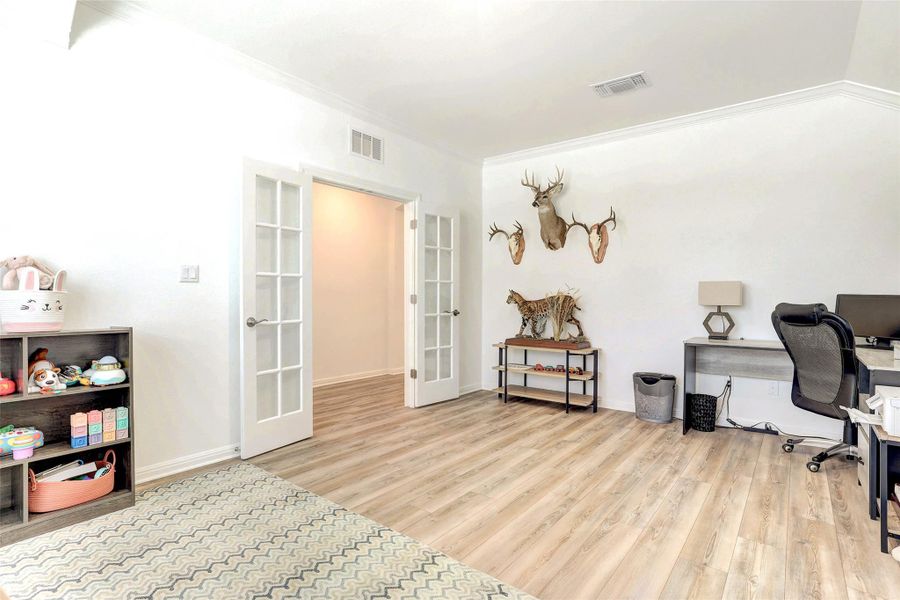 Office area with french doors, ornamental molding, and wood finished floors