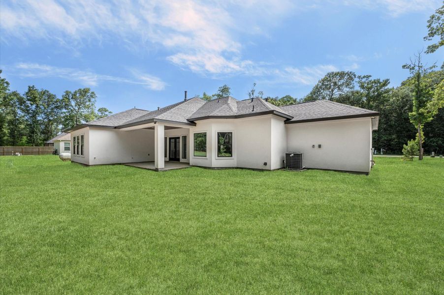 This photo showcases a modern, single-story home with a spacious backyard and a covered patio area, perfect for outdoor gatherings. The exterior is clean and well-maintained, set against a backdrop of lush greenery, offering privacy and tranquility. This photo showcases a modern, single-story home with a spacious backyard and a covered patio area, perfect for outdoor gatherings. The exterior is clean and well-maintained, set against a backdrop of lush greenery, offering privacy and tranquility.