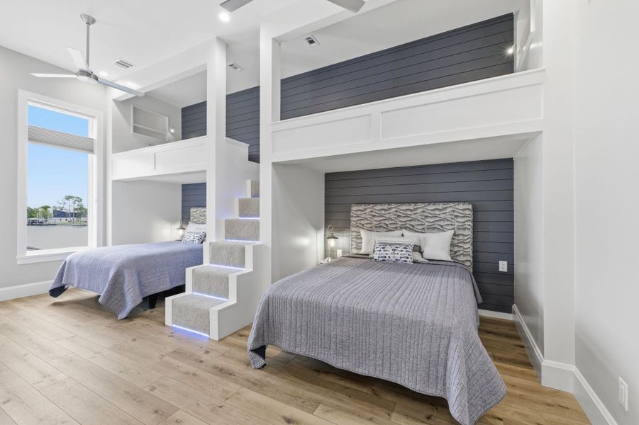 Bedroom with a high ceiling, light wood-style floors, and ceiling fan
