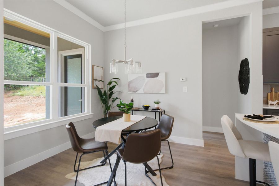 Natural light floods this inviting dining area, boasting sleek flooring and elegant crown molding. Natural light floods this inviting dining area, boasting sleek flooring and elegant crown molding.