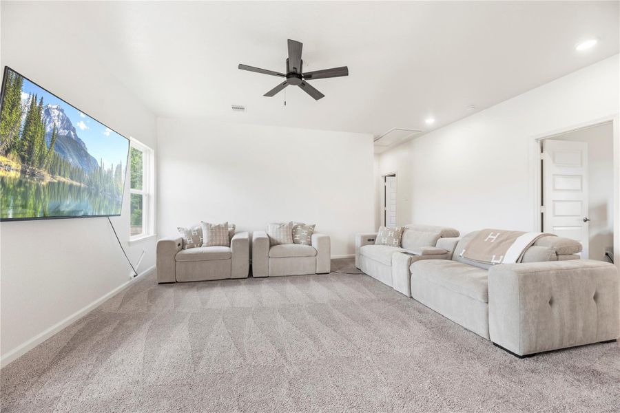 Versatile upstairs game room with plush carpet and a ceiling fan. Versatile upstairs game room with plush carpet and a ceiling fan.