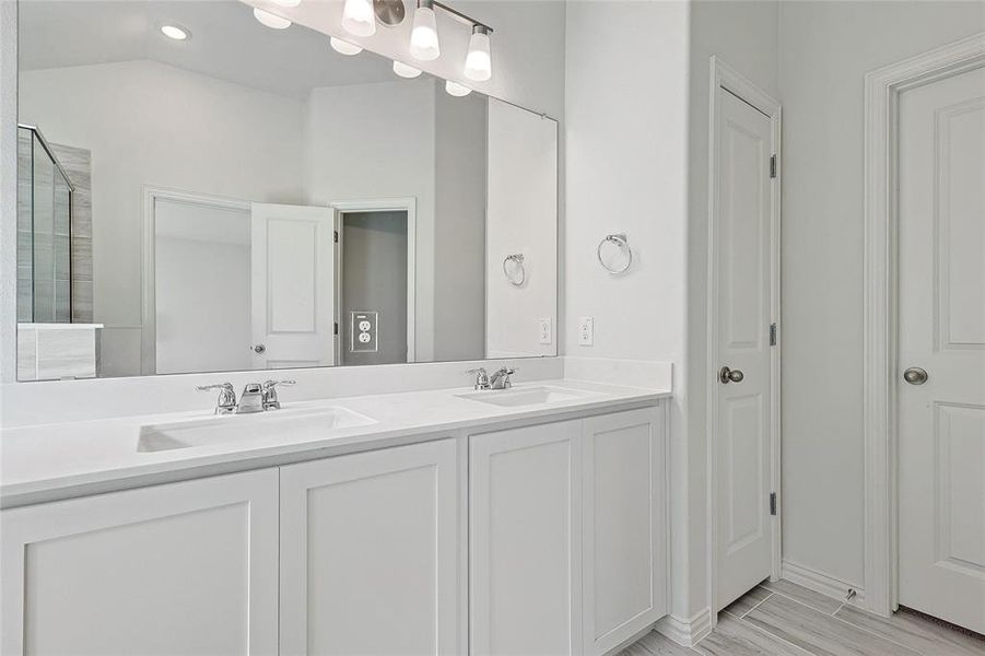 Bathroom with a shower, vanity, vaulted ceiling, and wood-type flooring