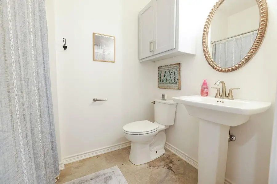 Full bath with a shower with shower curtain and baseboards