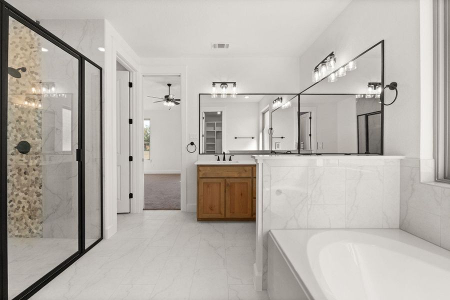 Full bath with light marble finish flooring, a marble finish shower, a garden tub, vanity, and ceiling fan
