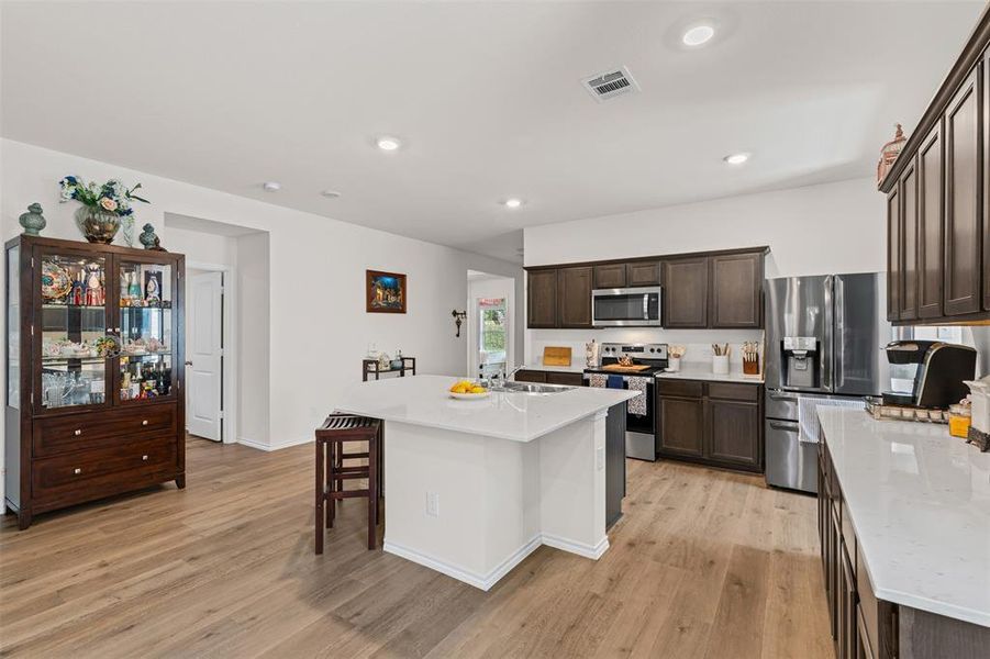 Open concept kitchen with large center island, quartz countertops, stainless steel appliances, and abundant cabinet space. Open concept kitchen with large center island, quartz countertops, stainless steel appliances, and abundant cabinet space.