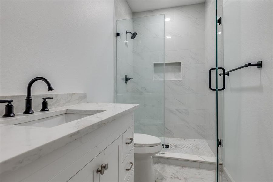 Bathroom with vanity, a marble finish shower, and light marble finish flooring Bathroom with vanity, a marble finish shower, and light marble finish flooring