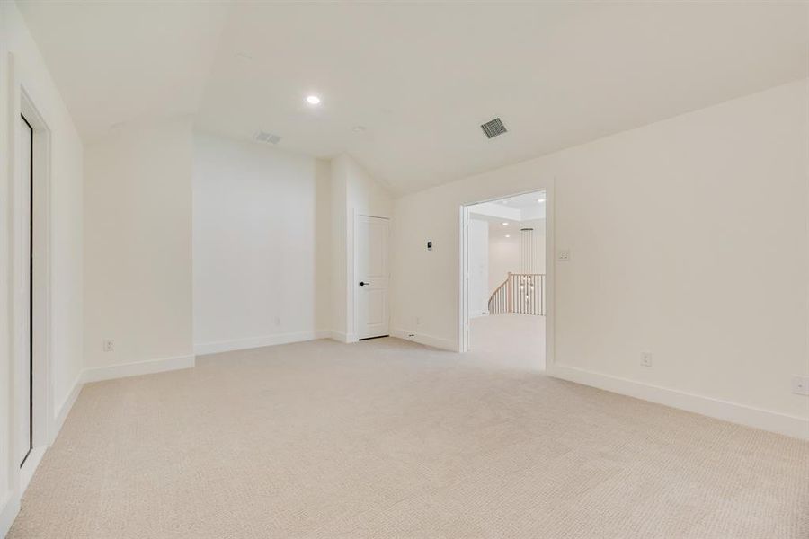 Spare room with light colored carpet, lofted ceiling, and recessed lighting Spare room with light colored carpet, lofted ceiling, and recessed lighting