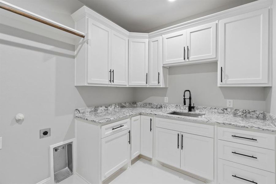 Washroom with sink, cabinets, and electric dryer hookup