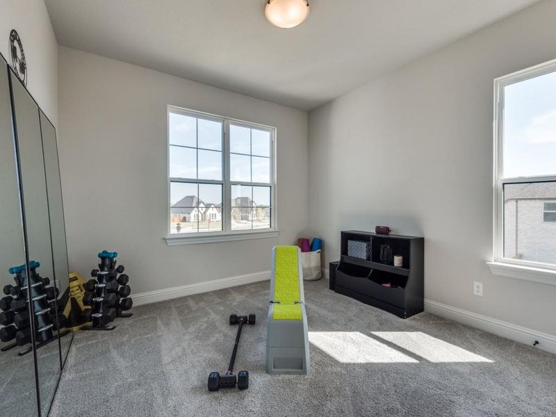 Exercise room featuring light carpet