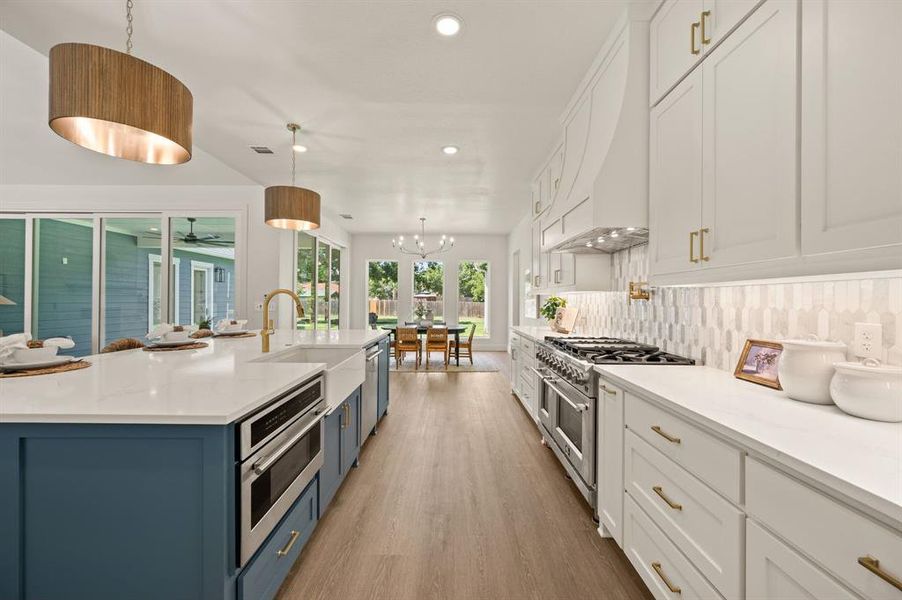Kitchen with blue cabinets, recessed lighting, white cabinets, range with two ovens, and light countertops Kitchen with blue cabinets, recessed lighting, white cabinets, range with two ovens, and light countertops