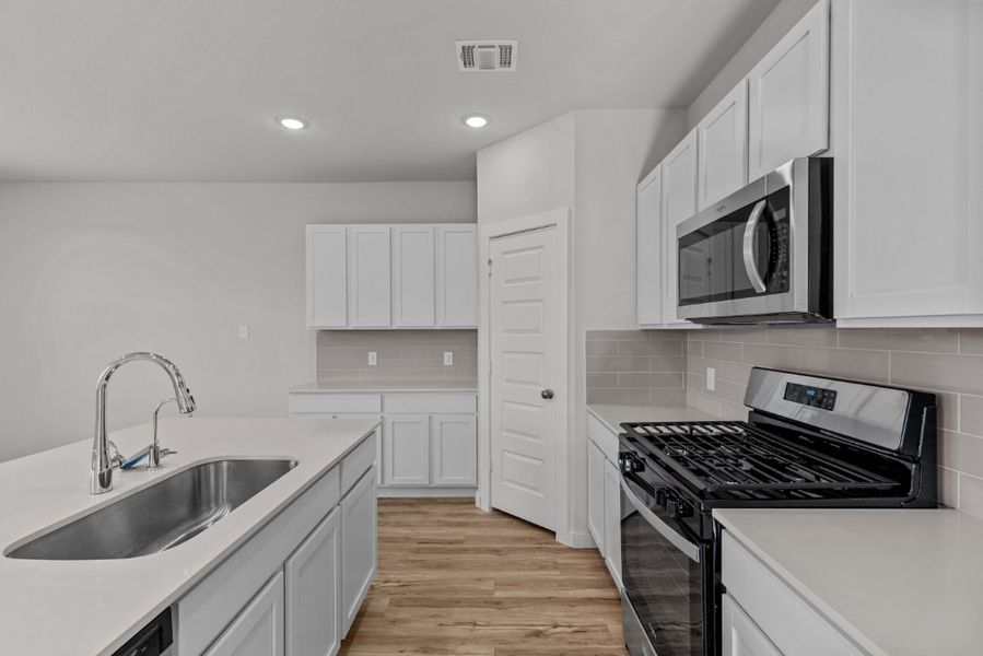 A kitchen with white cabinets.