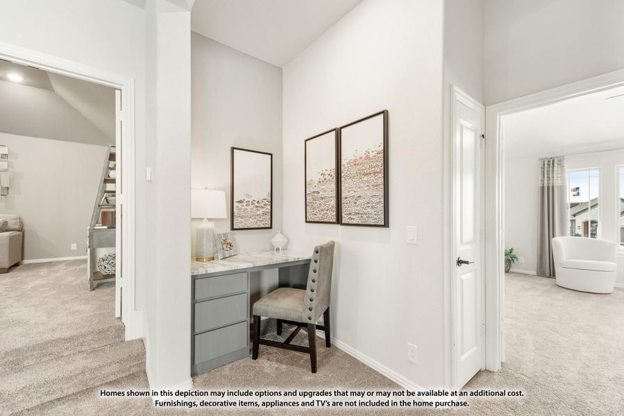 Built-in desk nook with gray drawers, marble top, and upholstered chair on beige carpet Built-in desk nook with gray drawers, marble top, and upholstered chair on beige carpet