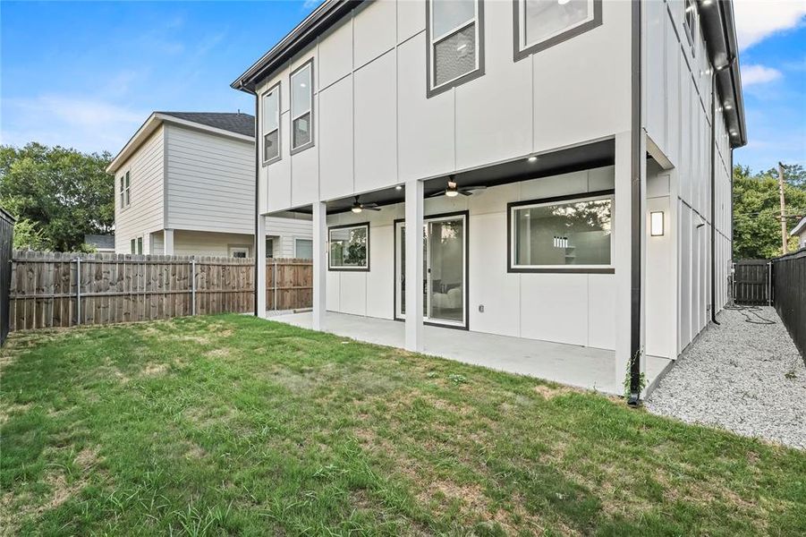 Back of house with a yard, ceiling fan, and a patio area