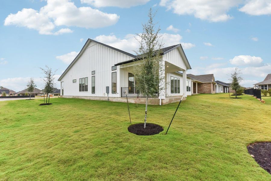 Back of property featuring board and batten siding, a patio, and a lawn Back of property featuring board and batten siding, a patio, and a lawn