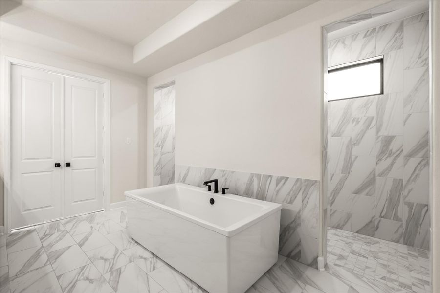 Opulent bathroom featuring a sleek freestanding tub, elegant marble, and a spacious walk-in shower, offering a spa-like retreat after a long day.