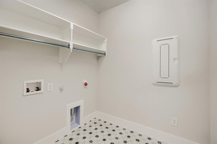 Utility room with patterned floor tile, overhead shelving, and a hanging rod