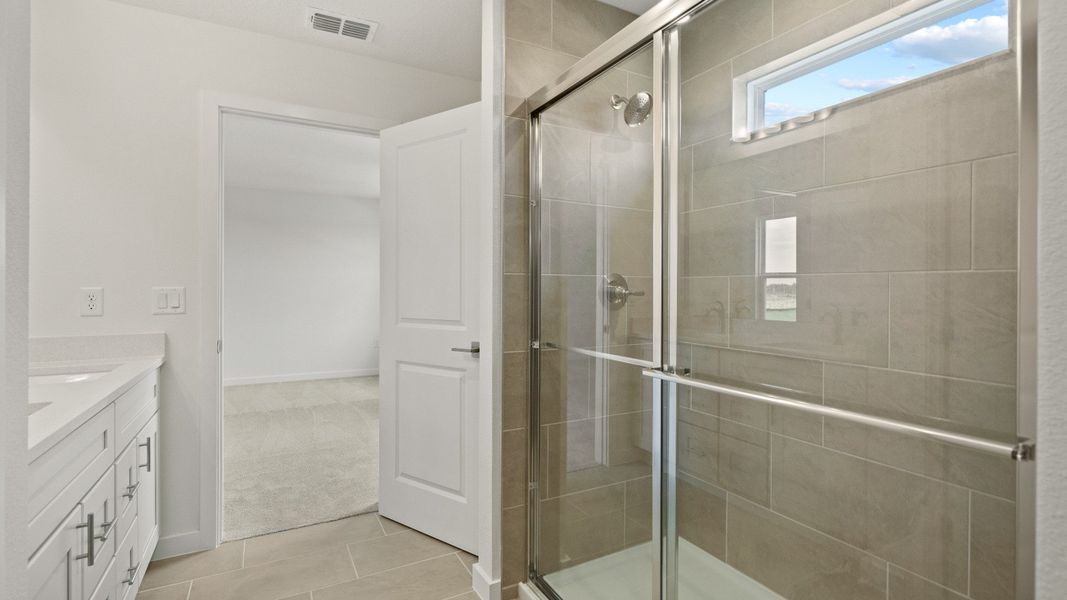 Contemporary primary bath featuring a sleek glass shower, dual sinks, and elegant tilework for a spa-like feel