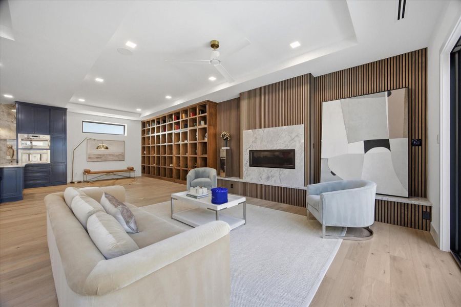 A statement in craftsmanship—the linear wood-paneled wall and sleek fireplace create a striking focal point, balancing warmth with modern precision.