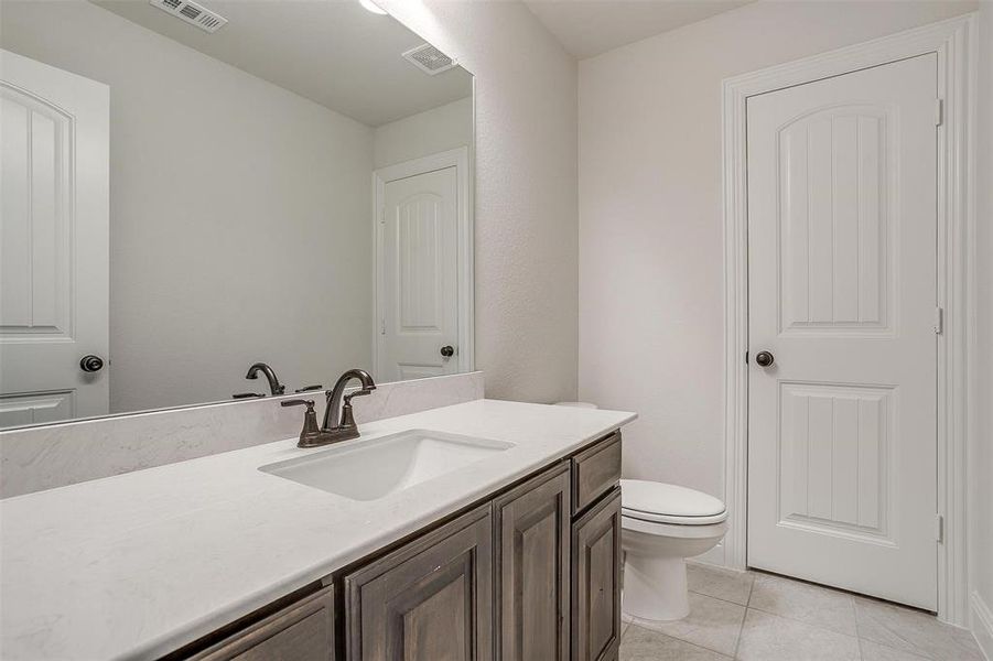 Bathroom featuring tile patterned floors, toilet, and vanity