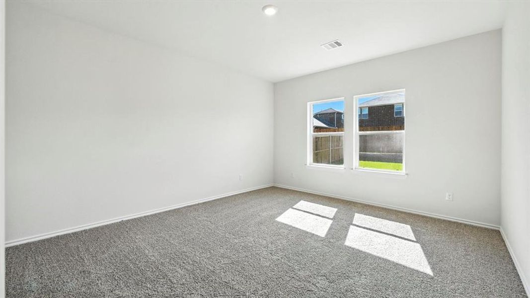 Room featuring two windows, neutral gray carpeting, white painted walls, and white trim