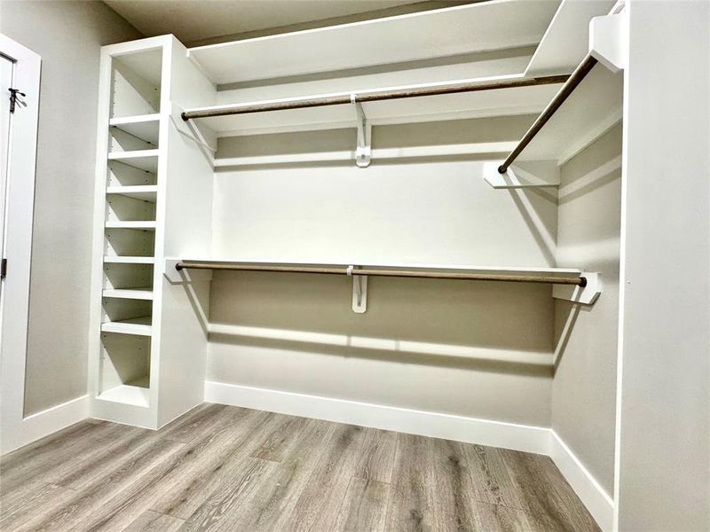 Primary bedroom closet with custom cabinetry.