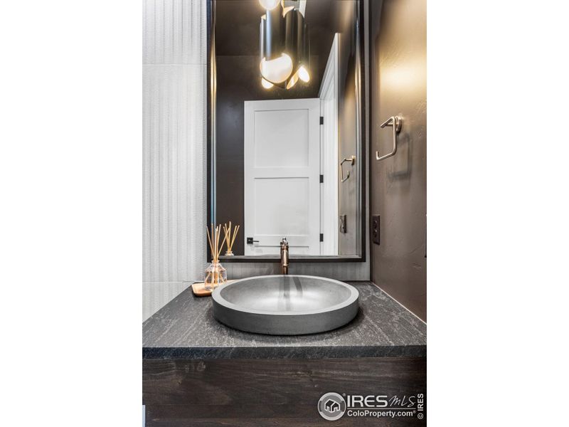 Conveniently located powder room with appealing dark accents