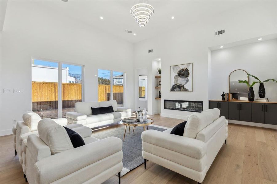 Living room with a towering ceiling and light wood-type flooring