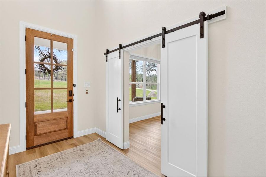 Foyer featuring light wood-type flooring and a barn door Foyer featuring light wood-type flooring and a barn door