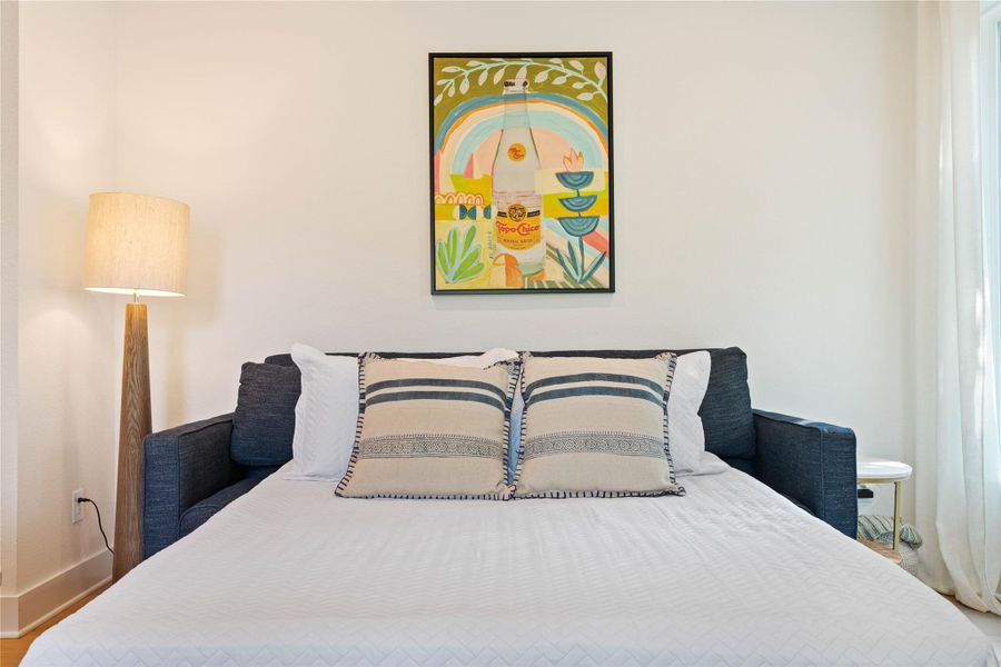 Smooth plaster walls and rich wood flooring frame this inviting sleeping area.