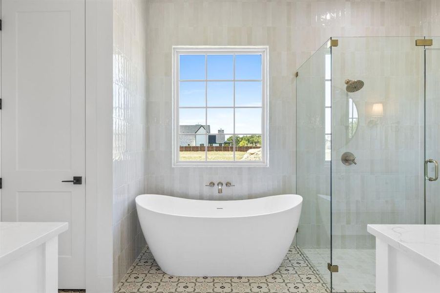 Bathroom featuring tile walls, separate shower and tub, vanity, and a healthy amount of sunlight