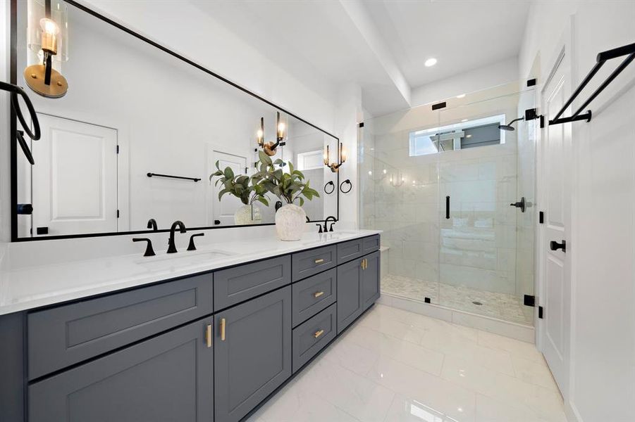 Luxurious primary bathroom featuring a spacious walk-in shower, double vanity, and elegant modern finishes.