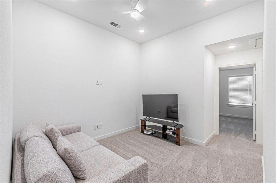 Living area featuring light carpet, ceiling fan, and recessed lighting