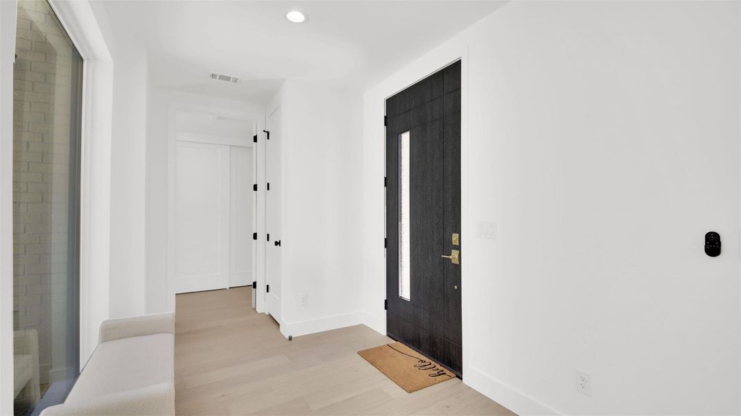 Entryway with light wood-style floors and recessed lighting