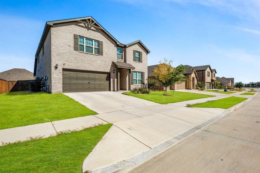 View of front of property with brick siding, concrete driveway, a garage, and a residential view View of front of property with brick siding, concrete driveway, a garage, and a residential view