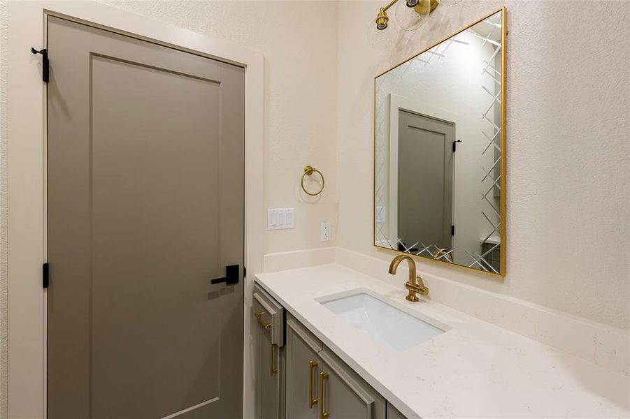 Bathroom featuring vanity and a textured wall