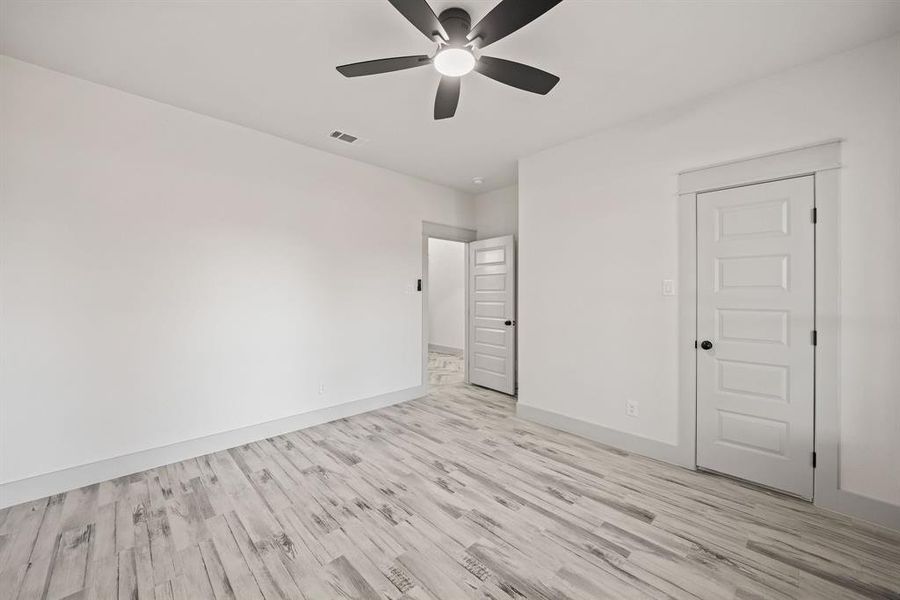 Unfurnished bedroom featuring a ceiling fan and light wood-style floors Unfurnished bedroom featuring a ceiling fan and light wood-style floors