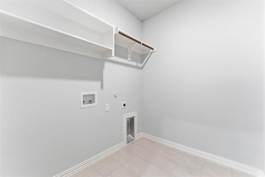 Washroom featuring gas dryer hookup, hookup for an electric dryer, washer hookup, and light tile patterned floors