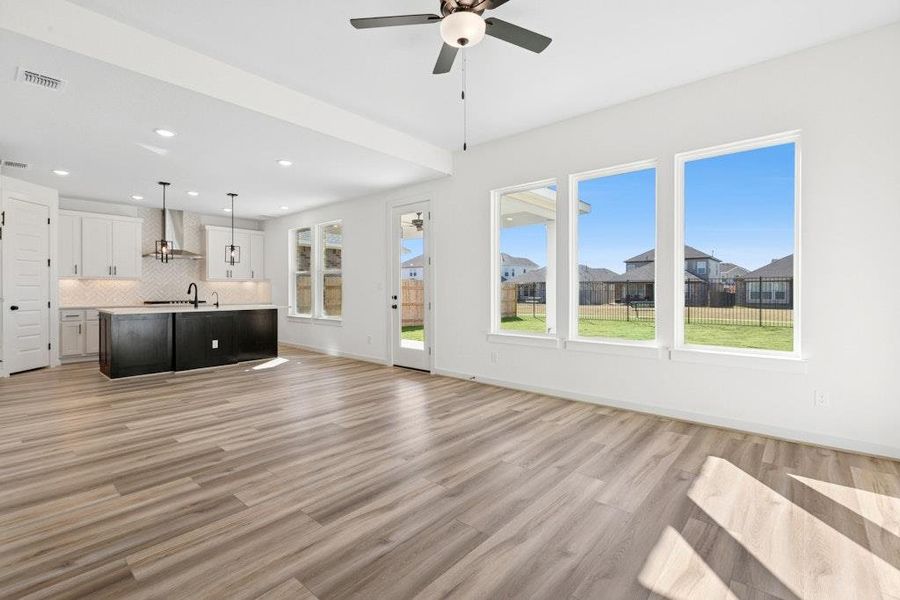 Unfurnished living room featuring light wood-type flooring, recessed lighting, ceiling fan, and a residential view