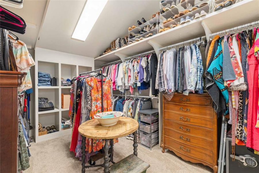 Expansive walk-in closet featuring built-in shelving, multiple hanging rods, overhead shoe storage, and recessed ceiling lighting