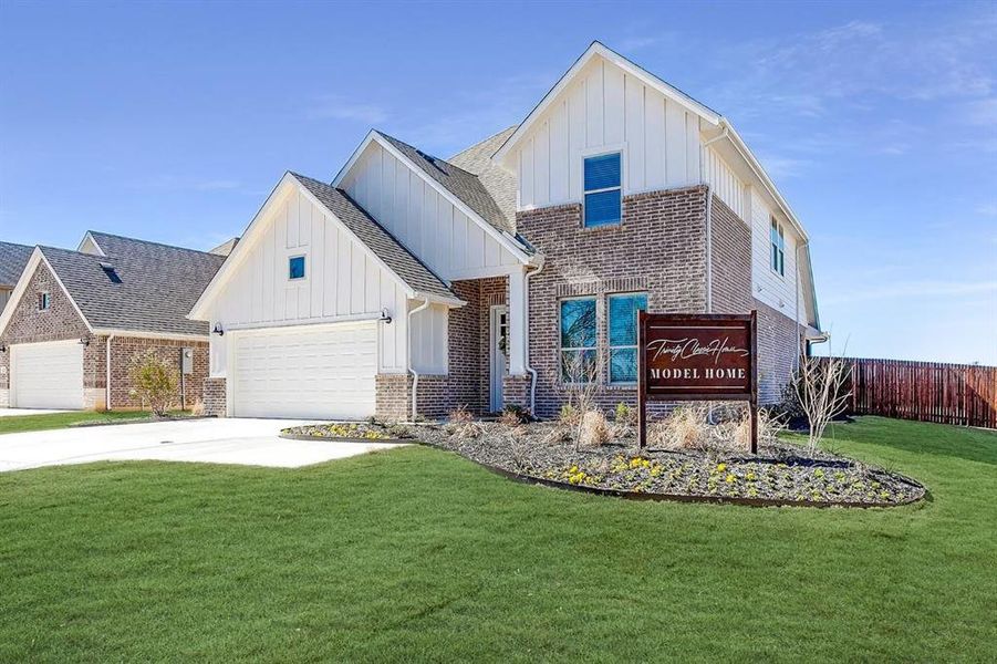 View of front of home with a garage and a front lawn