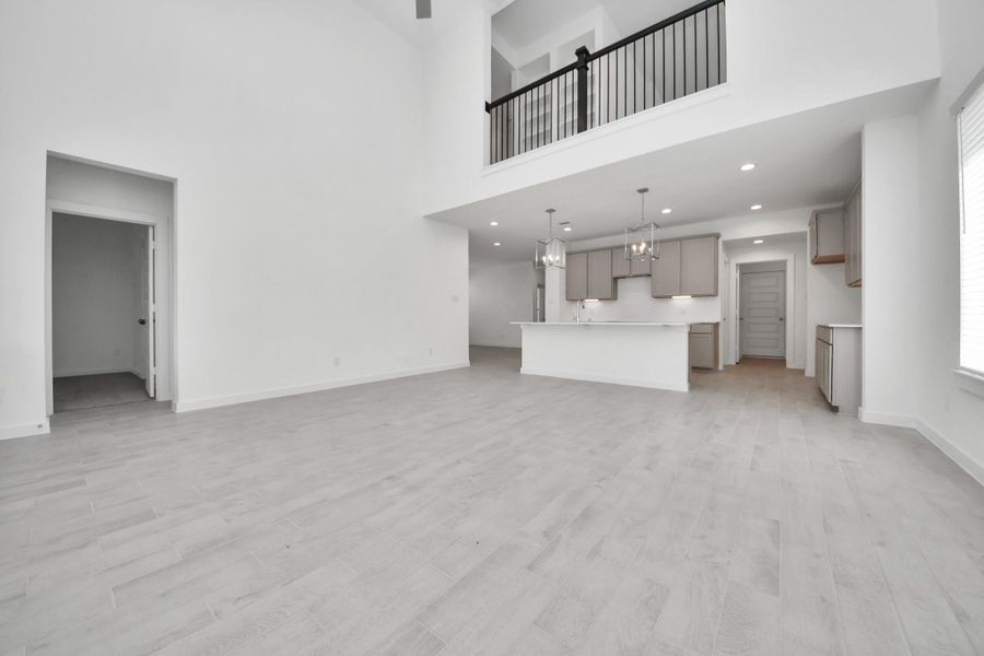 Gather the family and guests together in your lovely living room! Featuring soaring high ceilings, recessed lighting, ceiling fan, custom paint, gorgeous floors, and large windows that provide plenty of natural lighting throughout the day. Sample photo of completed home with similar floor plan. Actual colors and selections may vary.