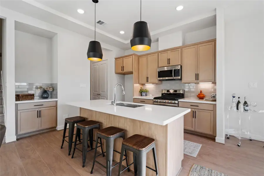 A quartz island with built-in bar seating anchors the kitchen and gives the space a natural gathering point beyond just cooking. A quartz island with built-in bar seating anchors the kitchen and gives the space a natural gathering point beyond just cooking.