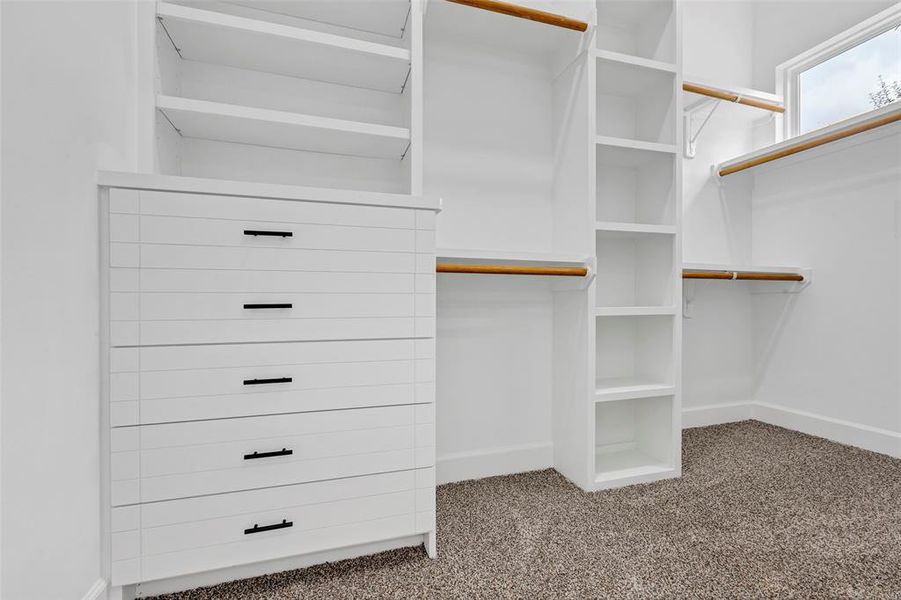 The walk in closet features built-in shelving and drawers. (Model Unit 9424C)