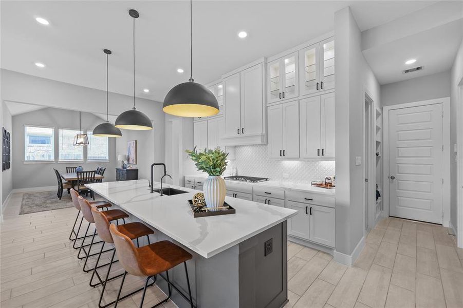 A modern kitchen with upgraded upper cabinets, enhanced by upper and under-cabinet lighting for a stylish and functional touch.